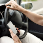 Person is driving and looking at phone