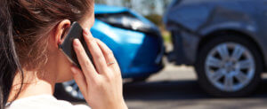 woman on the phone at a car accident scene